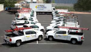 A fleet of HVAC Solutions service trucks and a box truck parked, ready for HVAC jobs in Colorado Springs, CO