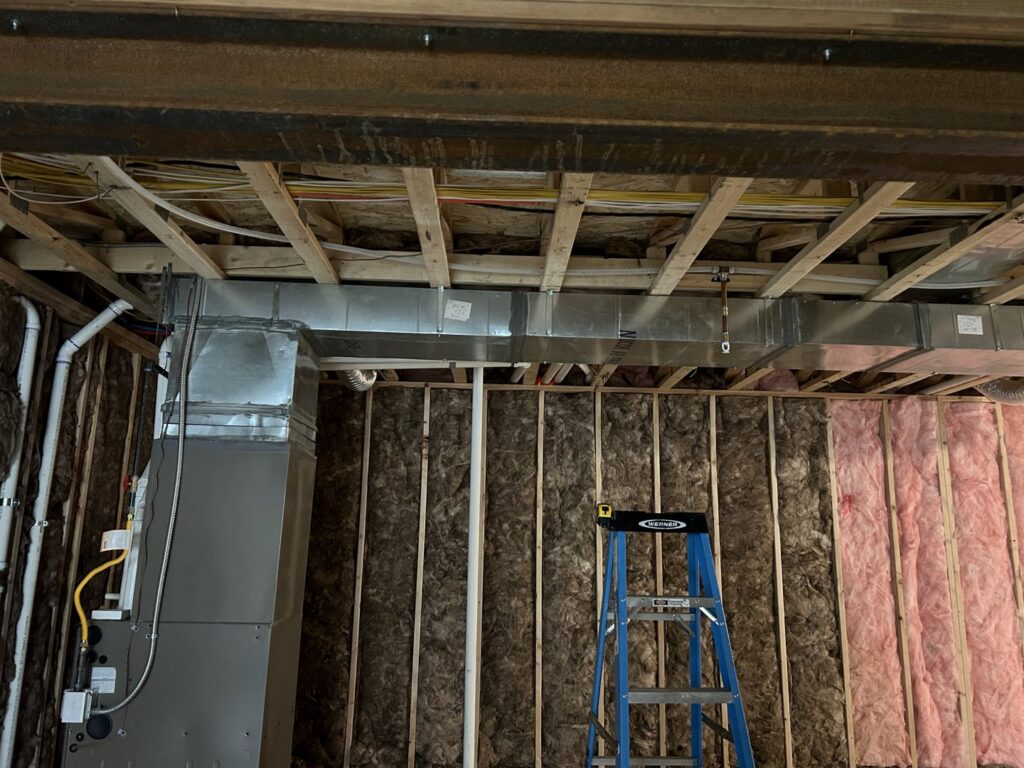 An HVAC system and ductwork installation in a basement under construction by R&R Mechanical Services in Greeley, CO.