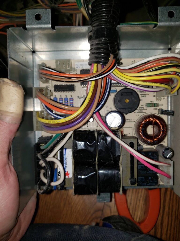 A detailed view of an HVAC system circuit board with various components and wiring by Thin Air Heating & Cooling Repair in Arvada, CO.