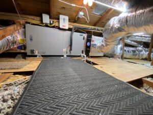 A newly installed HVAC system with an air handler and ductwork in an attic space by Pelican Heating and Air in Carlsbad, CA.