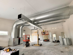 HVAC system installation in progress with technicians on lifts by Buck'n Bull HVAC Solutions in Wilmington, NC