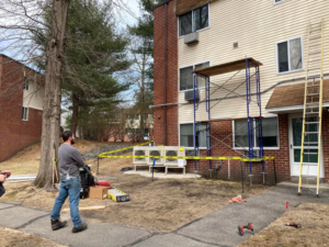 An HVAC system installation job site with outdoor condenser units and scaffolding for Express Plumbing in Hatfield, MA.