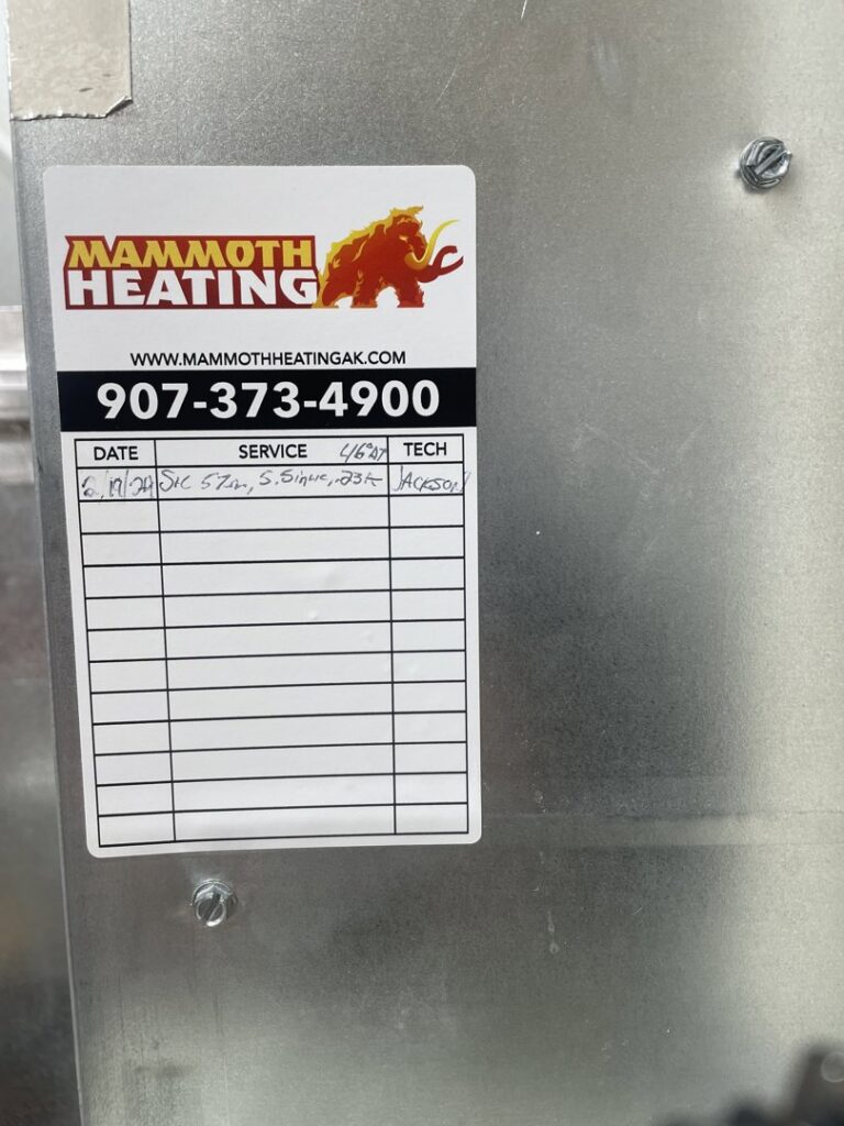 A detailed service label on an HVAC system after maintenance by Mammoth Heating in Wasilla, AK.