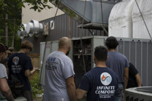 A team of Infinite Comfort technicians servicing a commercial HVAC unit in Youngsville, NC.