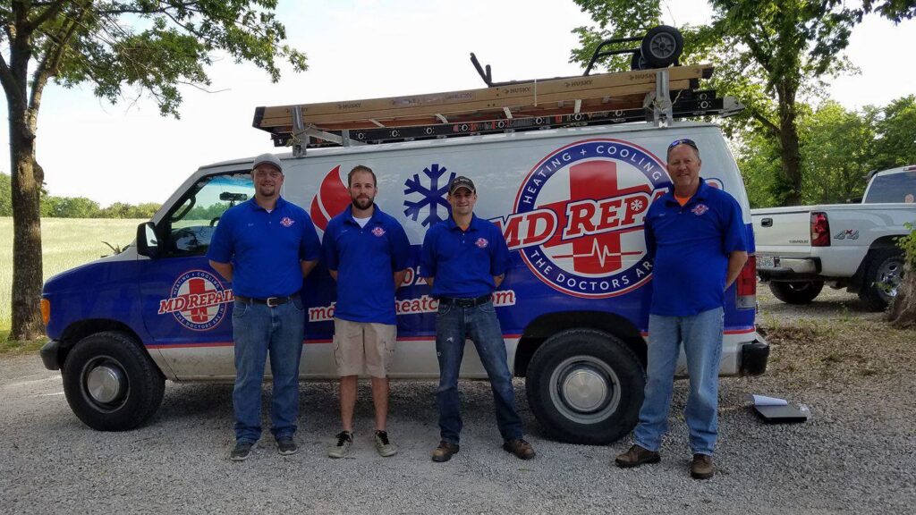 The HVAC team standing with their service van equipped with ladders for M.D. Repair Heating and Cooling in Oak Grove, MO.