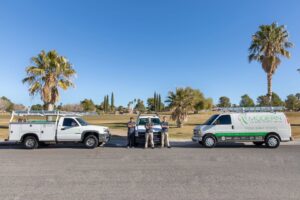Modern Air Conditioning & Heating team standing between their service vehicles in Boulder City, NV.