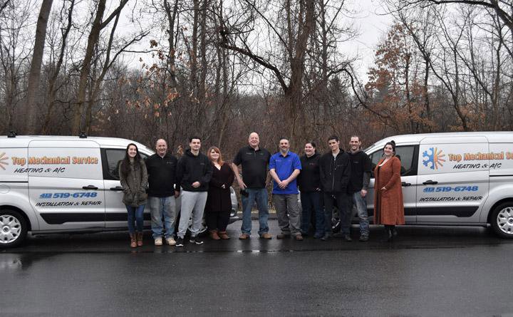The dedicated HVAC team standing proudly with their service vans from Top Mechanical Service in East Longmeadow, MA.