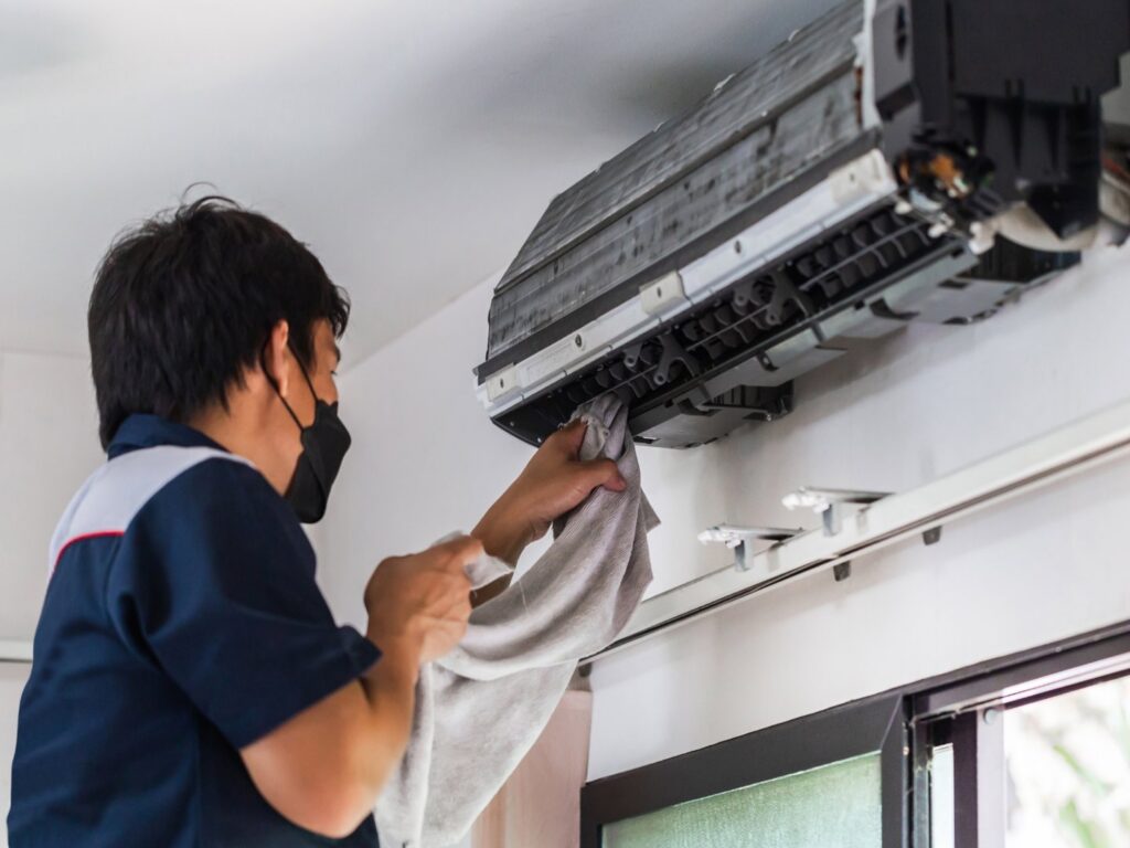 An HVAC technician checking an outdoor AC unit with gauges for ChillTek AC Repair Glendale in Glendale, AZ.