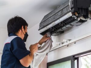 An HVAC technician checking an outdoor AC unit with gauges for ChillTek AC Repair Glendale in Glendale, AZ.