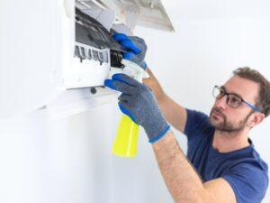 An HVAC technician diagnosing an outdoor AC unit with gauges for ChillTek AC Repair Glendale in Glendale, AZ.