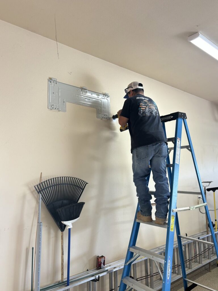 An HVAC technician installing a mini-split mounting bracket for Buddy's Refrigeration LLC in Mesquite, NV.