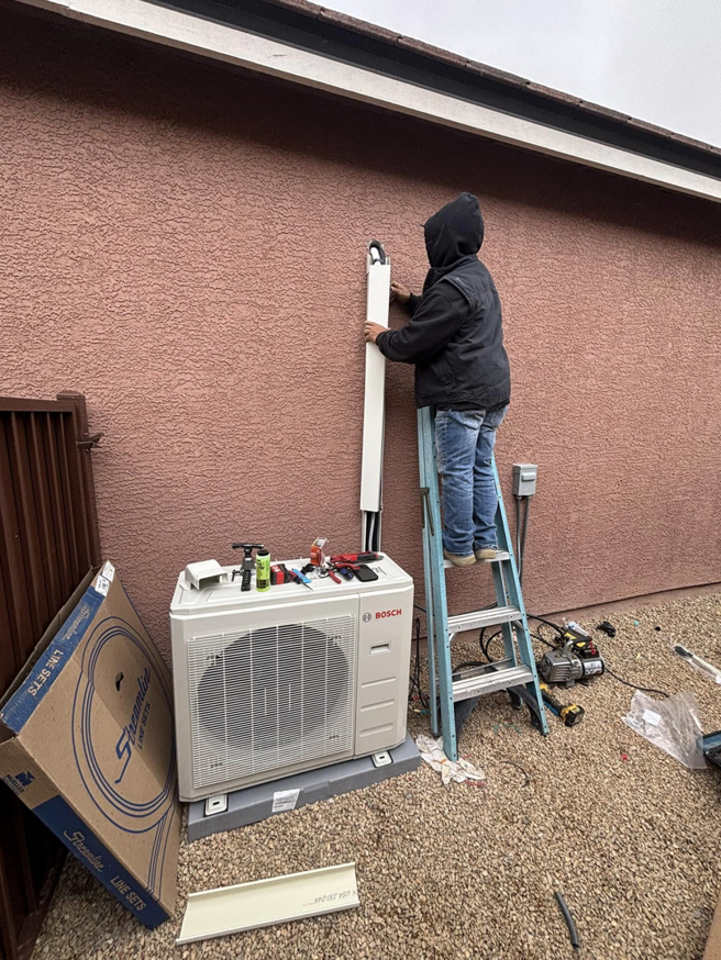An HVAC technician installing an outdoor mini-split condenser unit for Buddy's Refrigeration LLC in Mesquite, NV.