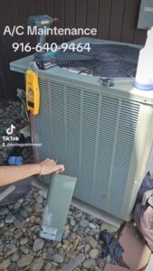 An HVAC technician performing air conditioning maintenance on an outdoor unit for Ecology Air Innovations in Sacramento, CA.
