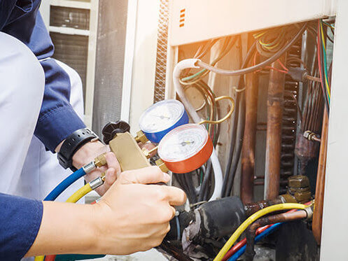 An HVAC technician checking refrigerant levels on an AC unit for Advanced Comfort Solutions, Inc. in Cheyenne, WY.