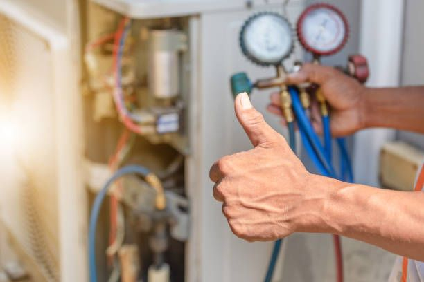 An HVAC technician giving a thumbs-up while performing AC repair with gauges at Team Mechanical, Inc in Minneapolis, MN.