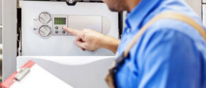 An HVAC technician adjusting the controls on a boiler or furnace for Baker Heating & Cooling in Dayton, OH.
