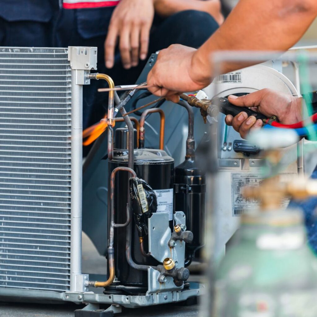 An HVAC technician brazing copper lines on an outdoor AC unit during a repair at Integrity Airworks in Hoover, AL.