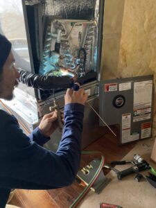 An HVAC technician brazing coils inside an air handler unit during a service job for Stanton Home Comfort in Fordland, MO.