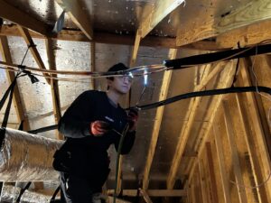 HVAC technician brazing copper refrigerant lines in an attic during installation for Benavidez Heating & Air Conditioning In, Arlington, TX.