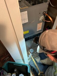 An HVAC technician from Fuse HVAC & Appliance Repair Boston brazing pipes on an indoor unit in West Roxbury, MA.