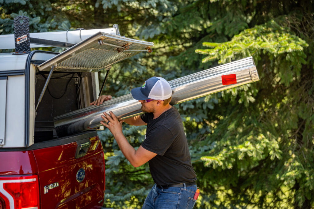 An HVAC technician from Comfort Craftsman Heating & Cooling carrying ductwork for an installation in Westland, MI.