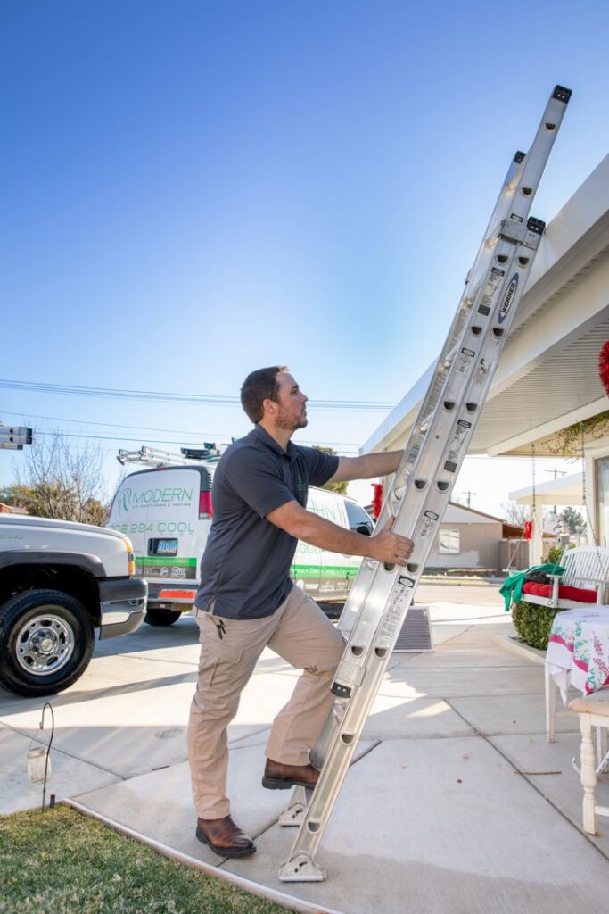 An HVAC technician carrying a ladder for a service call by Modern Air Conditioning & Heating in Boulder City, NV.