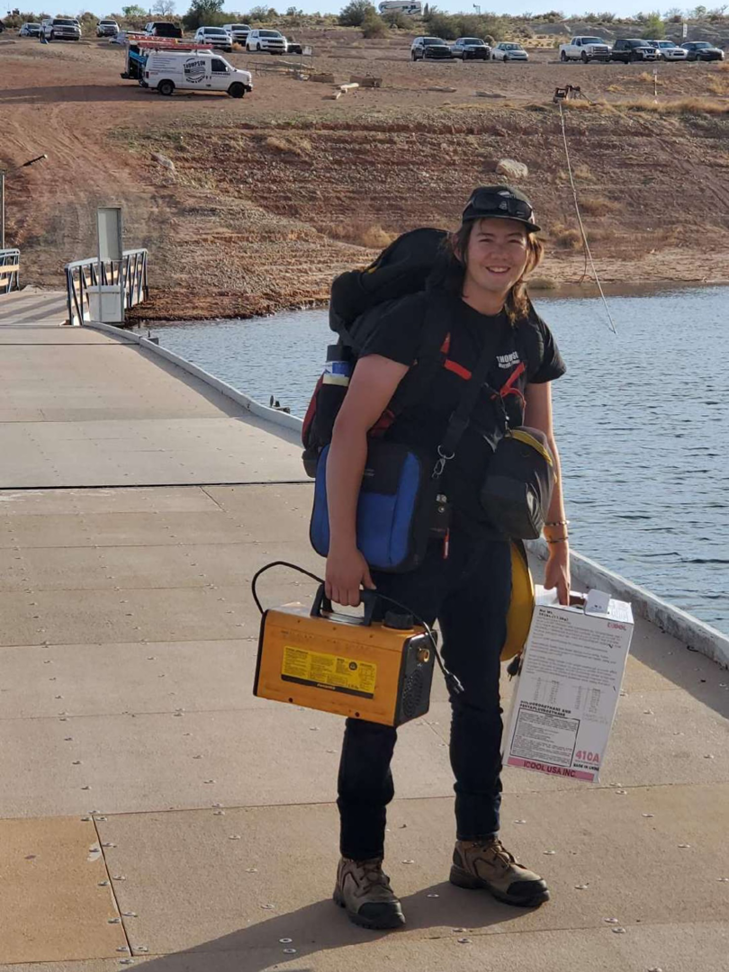 An HVAC technician carrying tools for a service call near the water at Thompson Heating & Cooling in Page, AZ