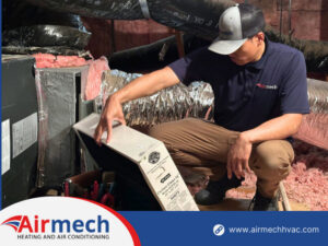 An Airmech Heating and Air Conditioning technician changing an air filter in an attic in Elk Grove, CA.