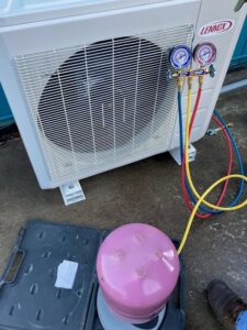 An HVAC technician charging a Lennox AC unit with refrigerant for S&A Heating And Cooling in Cornelius, OR.