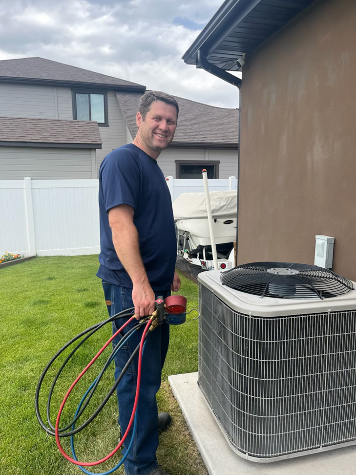 An HVAC technician from Dan's Heating & Cooling checking refrigerant levels on an outdoor AC unit in Las Vegas, NV