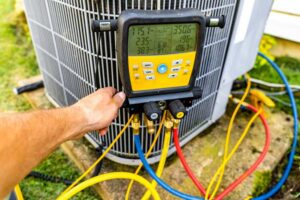 An HVAC technician checking refrigerant levels on an outdoor AC unit, a service provided by NorthStar Services in South Haven, MN