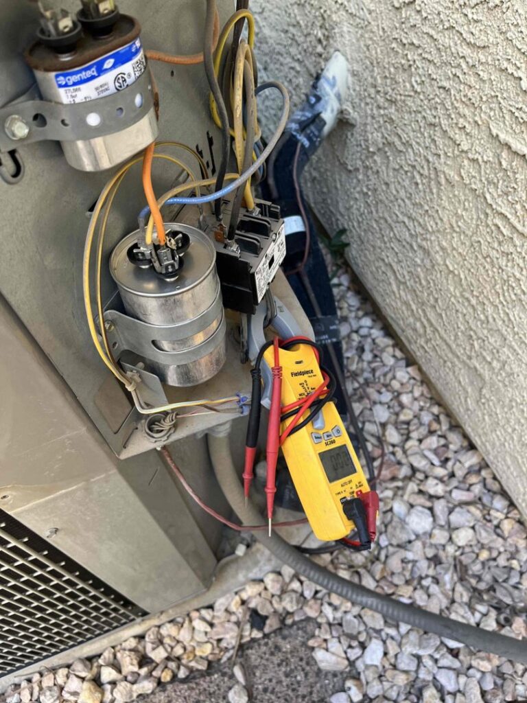 An HVAC technician checking the electrical components of an outdoor AC unit at a job site for Usa Air Conditioning & Heating in Las Vegas, NV