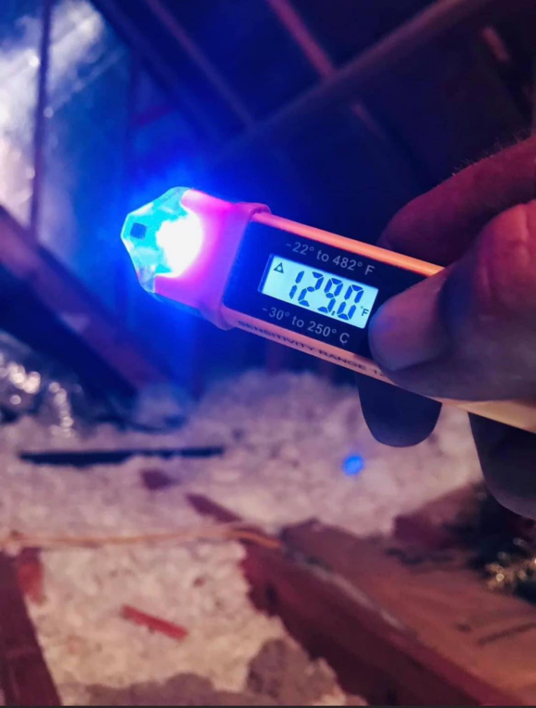 An HVAC technician checking the attic temperature with a digital thermometer for Advanced Comfort Concepts, Inc. in Raleigh, NC.