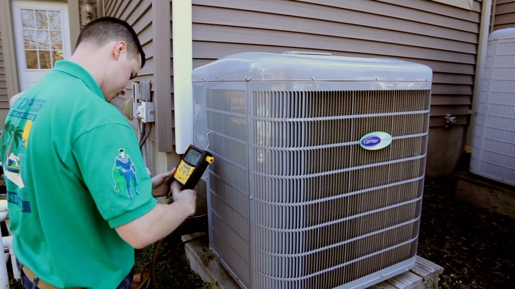 An HVAC technician from BC Express Inc Heating & Air Conditioning checking a Carrier AC unit in Toms River, NJ.