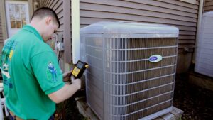 An HVAC technician from BC Express Inc Heating & Air Conditioning checking a Carrier AC unit in Toms River, NJ.