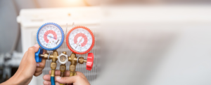 An HVAC technician checking refrigerant levels with manifold gauges for Air Fix in Fayetteville, AR.
