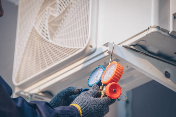 An HVAC technician checking refrigerant levels with gauges for Controlled Climate Solutions in Decatur, AL.