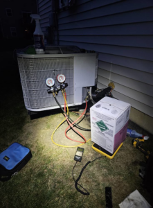 An HVAC technician checking refrigerant levels on an outdoor condenser unit for Dr. Cool Climate Control HVAC in Las Vegas, NV.