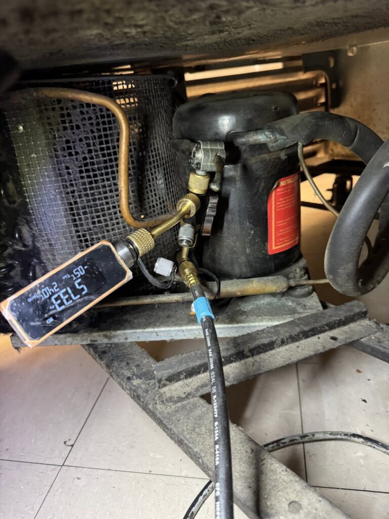 An HVAC technician checking refrigerant levels on an indoor unit compressor for LeoAir, LLC in West Jordan, UT