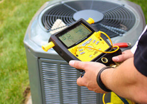 An HVAC technician checking refrigerant levels on an outdoor AC unit with a digital manifold gauge for Alien Air Conditioning and Heating in Phoenix, AZ.