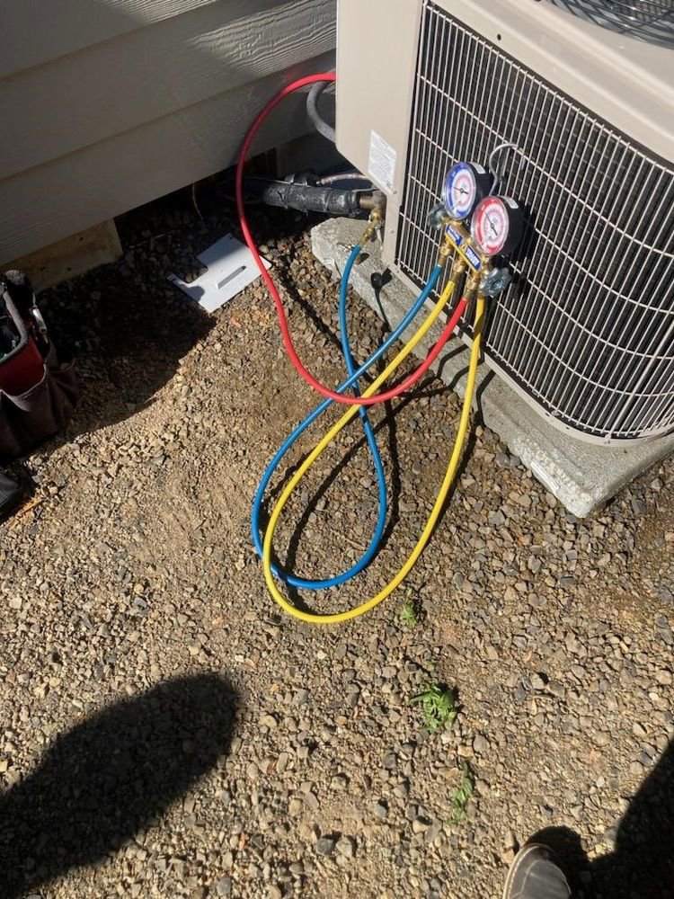 An HVAC technician checking refrigerant levels on an outdoor AC unit for S&A Heating And Cooling in Cornelius, OR.