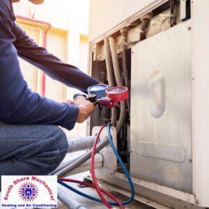 An HVAC technician checking refrigerant levels on an outdoor AC unit for South Shore Mechanical in Abington, MA