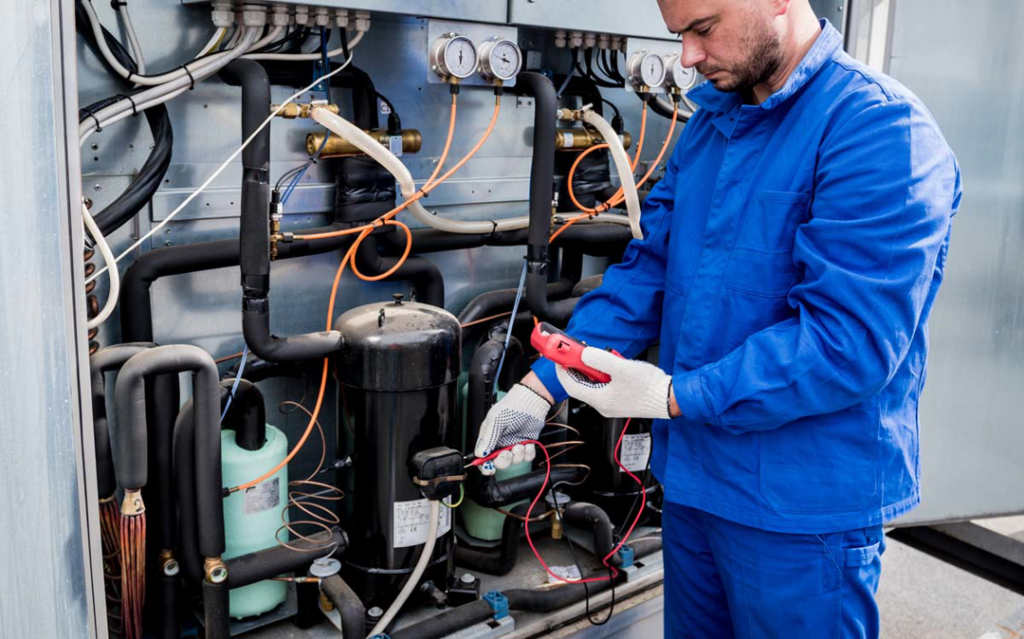 An HVAC technician from BTU Systems checking an industrial unit with a multimeter in Stamford, CT