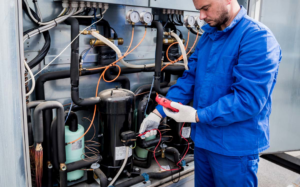 An HVAC technician from BTU Systems checking an industrial unit with a multimeter in Stamford, CT