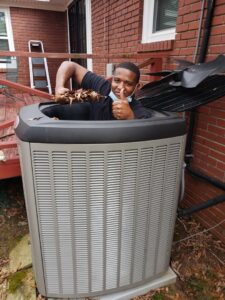 A Service Experts Memphis technician cleaning leaves from an outdoor air conditioning unit in Memphis, TN.