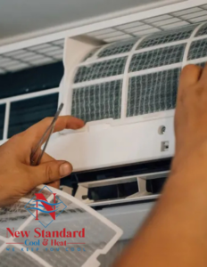 An HVAC technician cleaning an air filter from an indoor unit at a client's home by New Standard Air Conditioning Cool & Heat LLC in Winter Springs, FL.