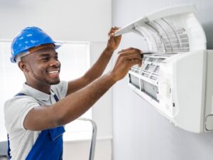 An HVAC technician in a mask cleaning an indoor AC unit for ChillTek AC Repair Glendale in Glendale, AZ.