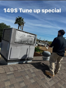 An HVAC technician cleaning a rooftop evaporative cooler for Rios Brothers Heating and Cooling LLC in Gilbert, AZ.