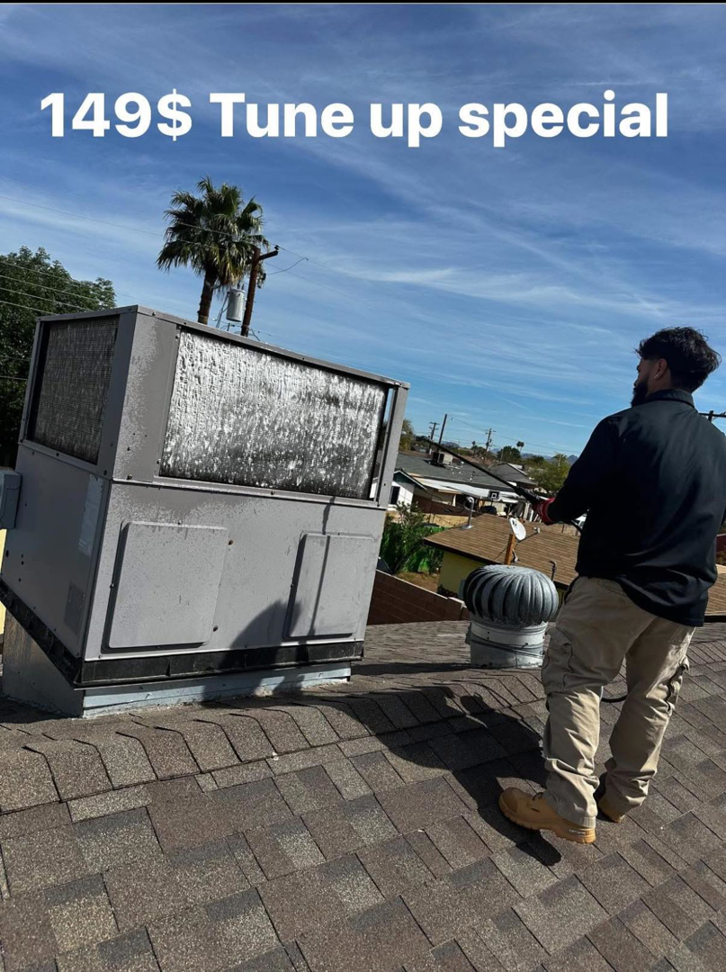 An HVAC technician cleaning a rooftop evaporative cooler for Rios Brothers Heating and Cooling LLC in Gilbert, AZ.