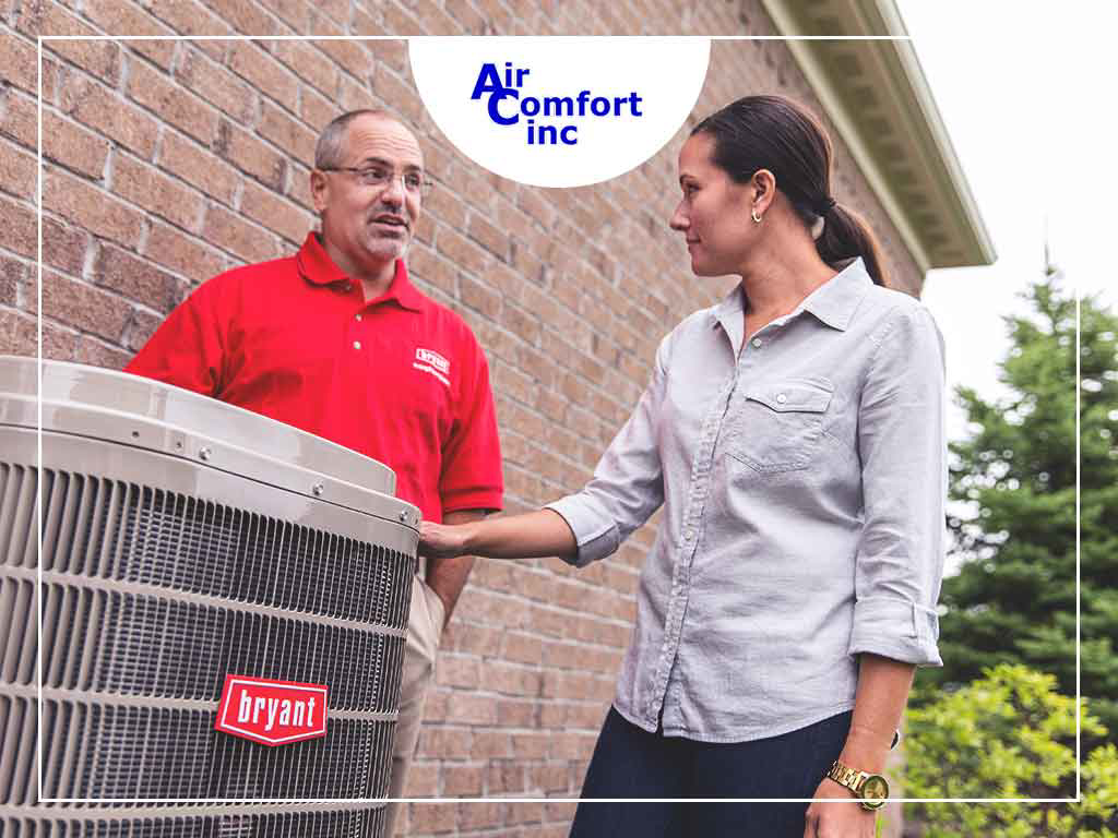 An Air Comfort, Inc. HVAC technician discussing an outdoor AC unit service with a client in Akron, OH.